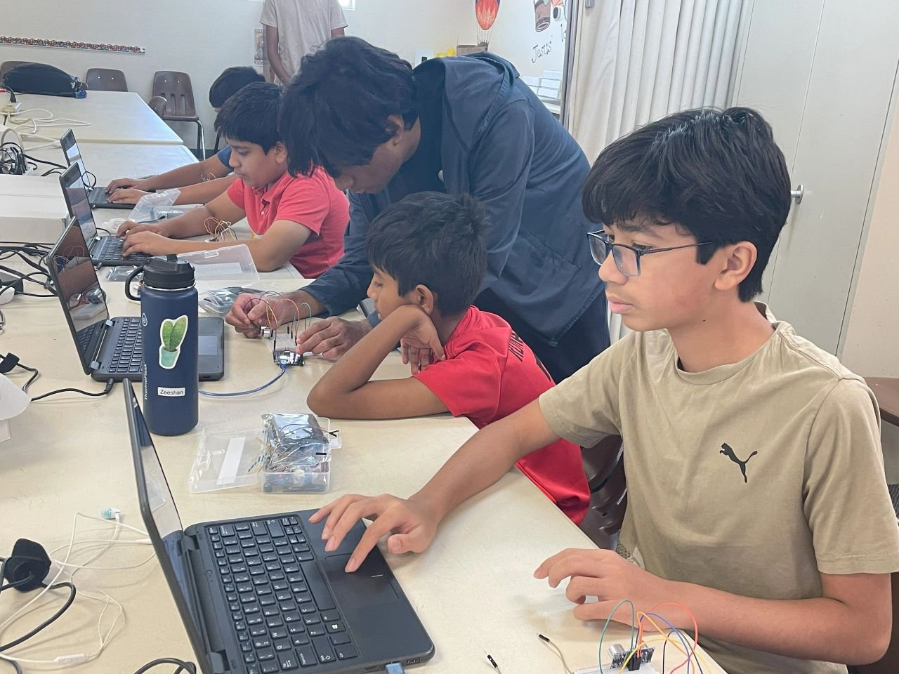 Students and an instructor working together in a technology classroom